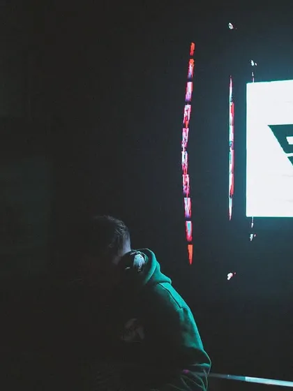 A darker, more mysterious shot where I'm a silhouette against my own logo. It shows that the brand is as much a part of the show as I am.