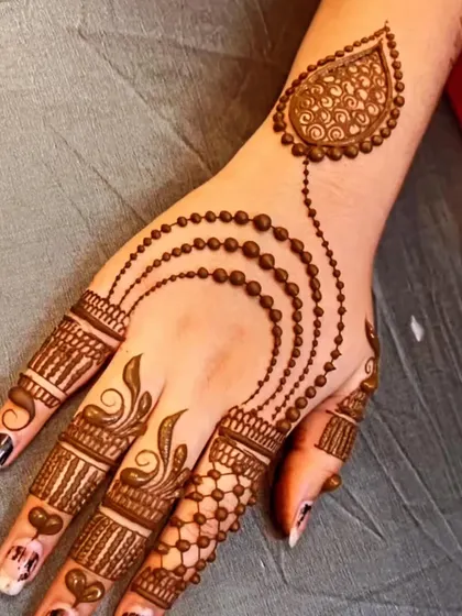 A very popular and elegant 'bel' design featuring beaded chains. This jewelry-inspired henna looks like a beautiful hand accessory and is perfect for any modern or traditional outfit.