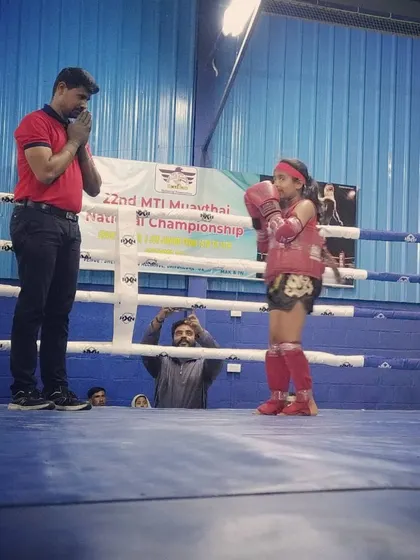 As a coach, I stand with my students every step of the way. Here, we are showing mutual respect in the ring just before her match at the Muay Thai National Championship.