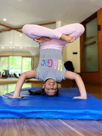 Magic is in the air. This student holds a beautiful lotus headstand, a testament to her focus and consistent practice.