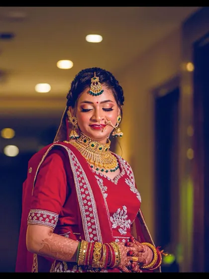 A beautiful, serene portrait of my North Indian bride. Her makeup features a soft shimmer on the eyes and a classic red lip, perfectly complementing her traditional red and gold bridal attire.