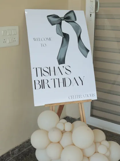 The welcome sign on an easel, with a small balloon garland at the base to tie it into the overall party decor.