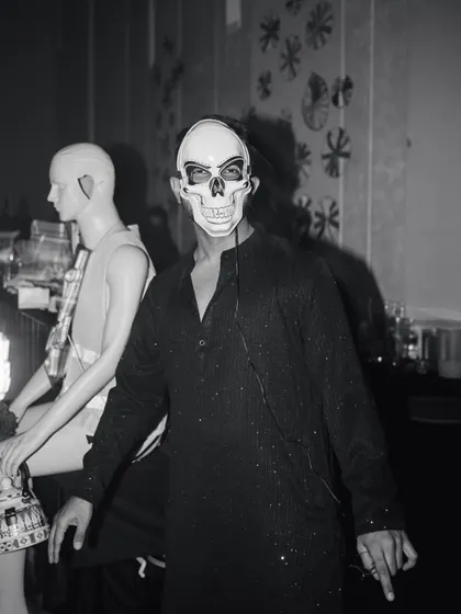 A guest embracing the "dark glam" theme with a skull mask, showcasing the immersive and theatrical nature of the afterparty.