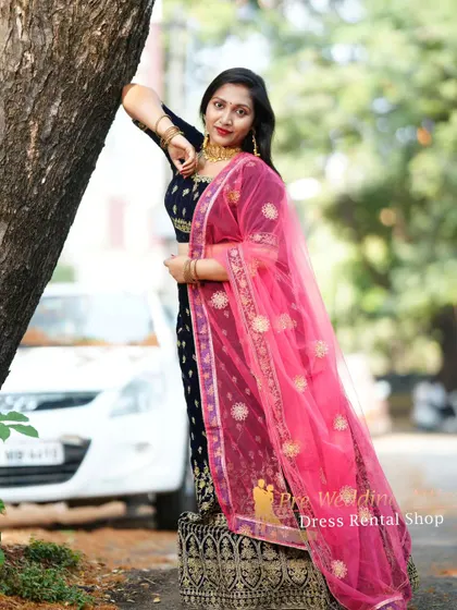 A dark blue velvet lehenga with gold embroidery, paired with a bright pink dupatta for a pop of color.
