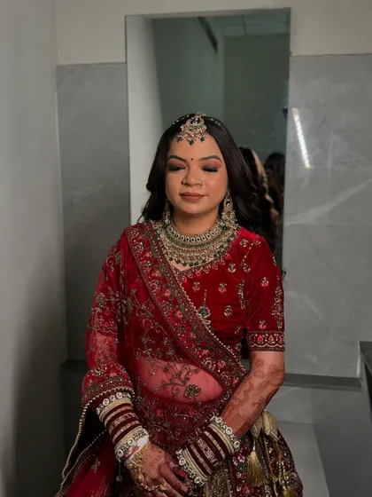 A serene moment captured before the wedding festivities. The smoky eye makeup adds a touch of glamour to her radiant look.
