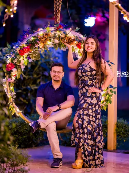 A fun and stylish pose on the floral swing, lit up for a night shoot. This setup is perfect for capturing both romantic and playful moments.