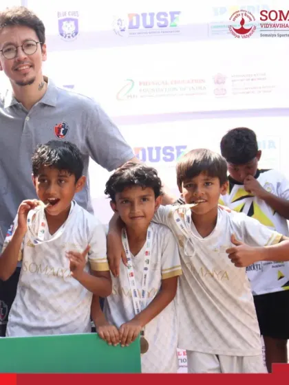 A coach celebrates with our U-9 players, highlighting the strong bond and mentorship within our academy.