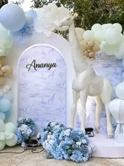 A dreamy pastel take on an animal theme for Ananya's first birthday, featuring a gentle giraffe, hot air balloon props, and a soft blue and beige color palette.