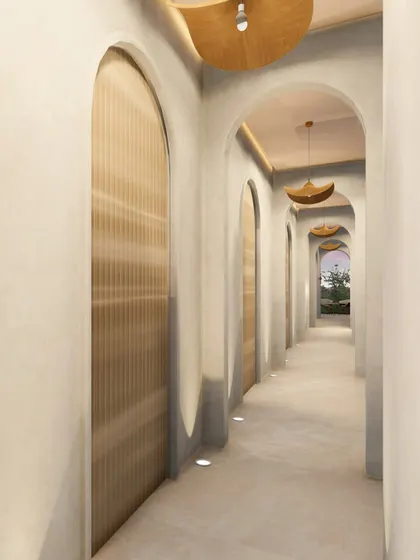 Another perspective of the archway corridor, highlighting the ombré-painted metallic mirrors that add a subtle touch of color and character to the otherwise monotone palette.