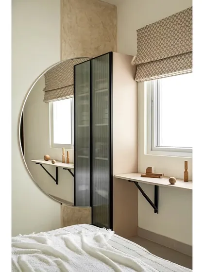 In this guest bedroom, I installed a pull-up ledge beneath the window. This provides a functional workspace or display area when needed, and folds down to save space, demonstrating a smart use of a small nook.
