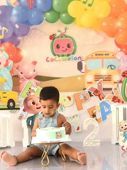 A Cocomelon-themed cake smash is a dream come true for many toddlers. This little one is digging into his cake, surrounded by all his favorite characters.