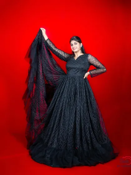 The long sleeves and flowing trail of this black gown add a touch of grace and elegance.
