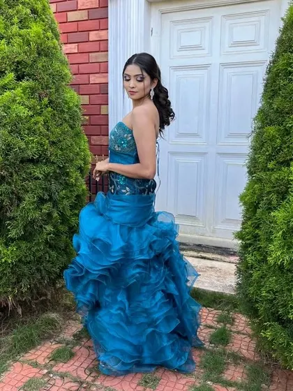 The back of this blue ruffled gown features a corset-style lace-up detail. It's a beautiful dress from every angle, perfect for making an impression.