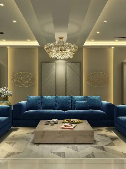 This living room exudes sophistication with its plush sapphire blue sofas set against a neutral, paneled wall. The grand crystal chandelier and dual ceiling fans ensure both style and comfort.