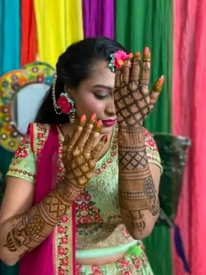 A happy bride showing off her jaali-style mehndi on the back of her hands, a popular choice for engagement ceremonies.