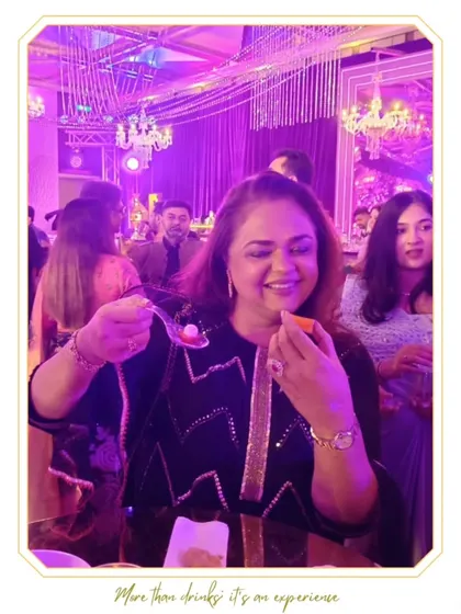 A guest delighted by our molecular gastronomy creations. This edible sphere is a burst of flavor, offering a unique and interactive tasting experience.