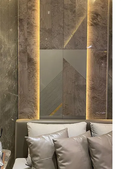Detail of a wall panel behind a headboard, featuring a geometric composition of wood veneer, matte panels, and vertical lighting strips. This is how we turn a simple wall into a piece of architectural art.