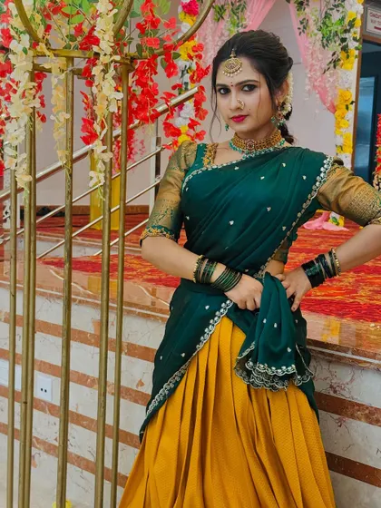 A client looking radiant in a green and yellow half saree. This traditional attire is perfect for temple visits, pujas, or any cultural event where you want to look elegant and graceful.