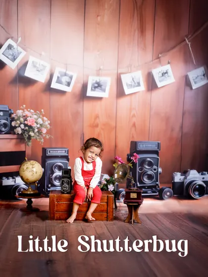 A little shutterbug in the making. This setup, complete with a photo garland and classic cameras, creates a nostalgic and creative atmosphere for a unique photoshoot.