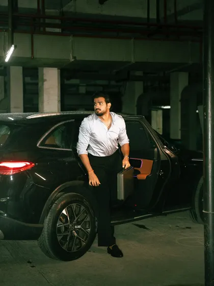 An on-location shoot with a strong narrative feel. The moody lighting of the underground parking lot and the dynamic pose create a cinematic moment, perfect for a men's fashion editorial or a brand campaign that tells a story.