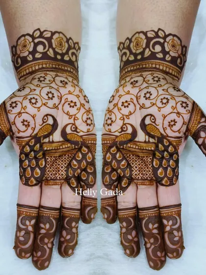 A delicate and symmetrical peacock design. The facing peacocks create a sense of harmony, while the intricate 'jaal' (net) pattern on the palm adds a layer of traditional elegance.