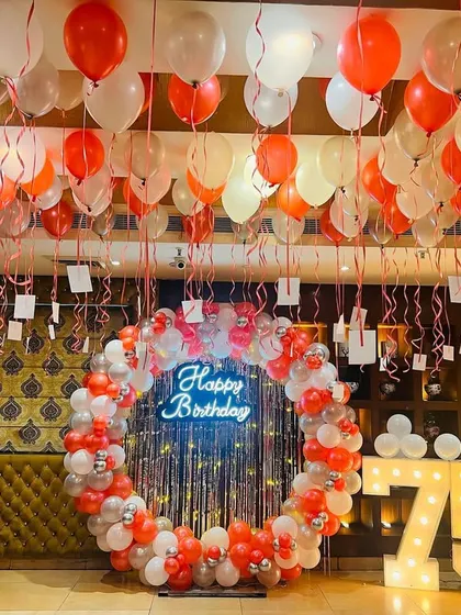 A classic red, white, and silver theme for a 75th birthday, with a circular balloon backdrop and ceiling balloons.