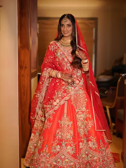 A full-length shot showing the bride's radiant smile and her stunning traditional attire. The makeup is fresh and luminous, perfect for a day wedding.