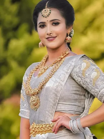 An elegant outdoor shot featuring a model in a silver-grey saree, perfectly contrasted with our antique gold rental jewellery.