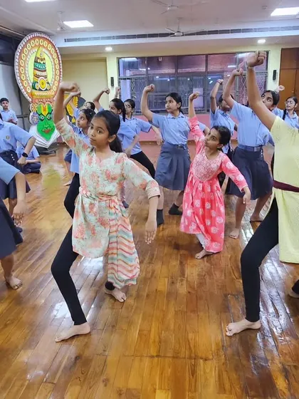 A group of schoolgirls learning a powerful Chhau sequence, combining their school uniforms with traditional dance postures.