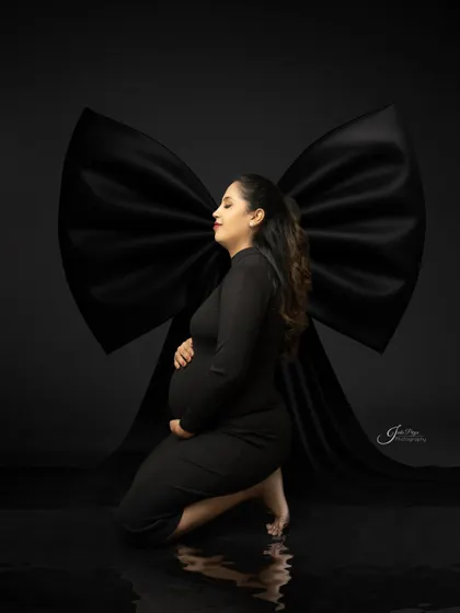 This is an example of my fine art maternity style, using dramatic lighting and a simple black gown. The focus is entirely on the mother's silhouette, creating a powerful and elegant portrait.