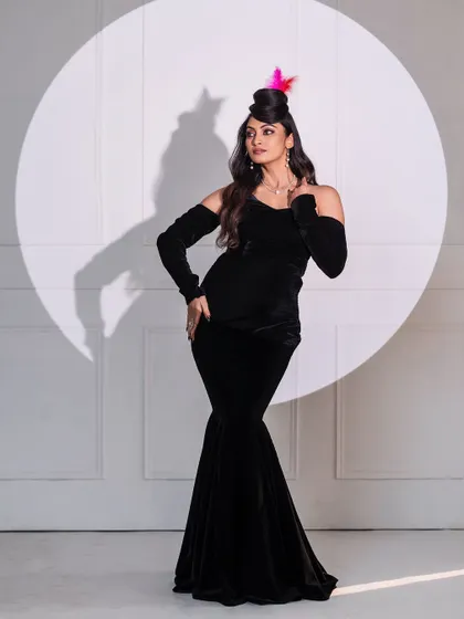 A retro-glam look with a black velvet fishtail gown and a creative hairstyle. The spotlight effect adds a touch of old-school Hollywood glamour.