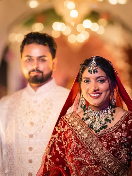 A beautiful portrait of the bride and groom. Her makeup looks radiant against the warm lighting of the venue.