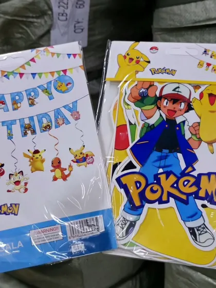 I stock supplies for Pokémon-themed parties, including Happy Birthday banners and character cutout sets featuring Ash and Pikachu.