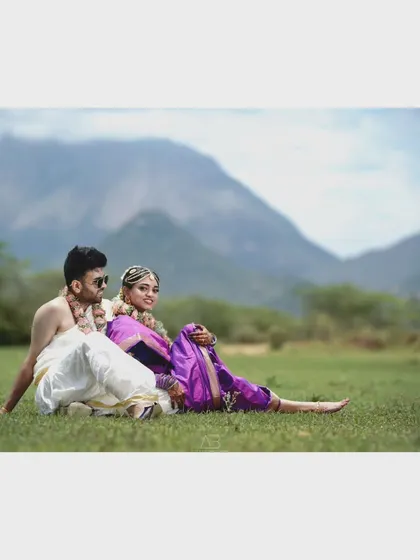 A wide shot that sets the scene, showing the couple relaxing in a beautiful meadow with mountains in the distance. This is great for establishing the location of a destination shoot.