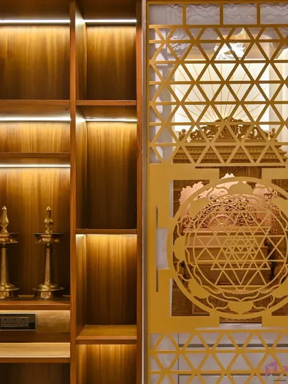 A close-up of a custom pooja unit door featuring an intricate 'Shri Yantra' laser-cut jaali design. The backlighting creates a beautiful, divine glow.
