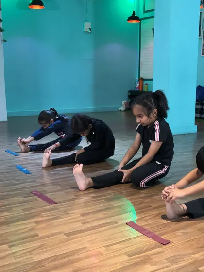 Working on seated stretches. Each student focuses on their own progress while being motivated by the group.