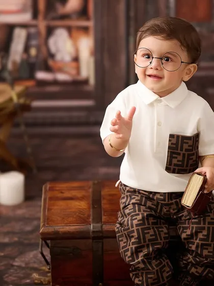 This little gentleman looks ready to hit the books in our library-themed setup. The rich, warm tones and classic props create a sophisticated portrait.
