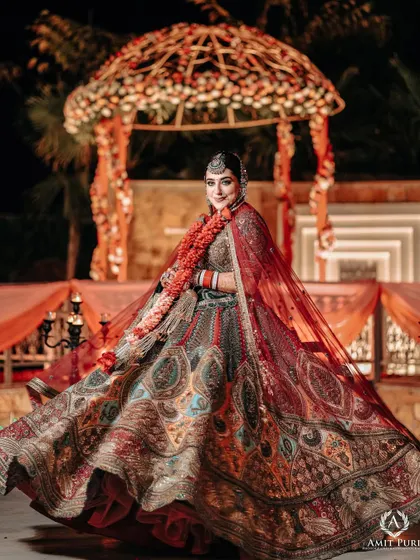A joyful, twirling shot of the bride in her multi-colored lehenga. This portrait captures her happiness and the beautiful movement of her outfit against the backdrop of the mandap.
