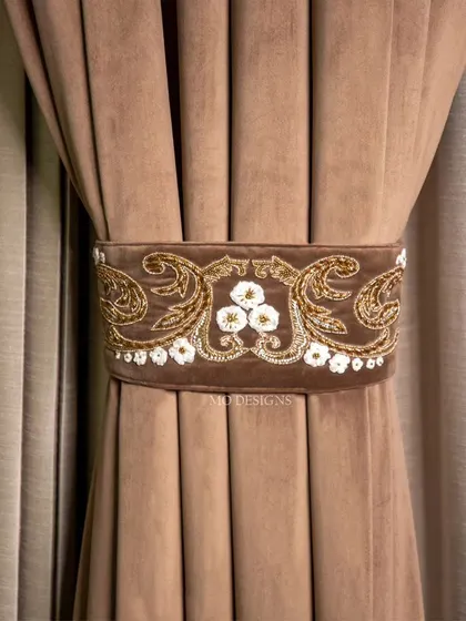 A handcrafted tie belt, featuring intricate gold and white floral embroidery on a soft brown velvet. This is not just an accessory, but a statement piece that reflects your unique style.