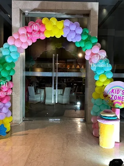 A rainbow balloon arch creates a fun and inviting entrance to the kids' zone at the Candyland party.