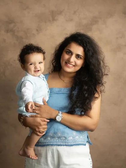 A beautiful, classic portrait of a mother and her smiling baby looking directly at the camera. This is a timeless shot that every family cherishes.