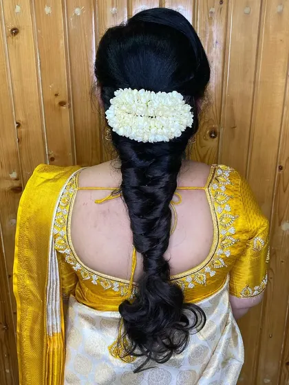 A classic fishtail braid paired with a simple jasmine gajra. This is a timeless and elegant choice for any wedding guest or bridesmaid.