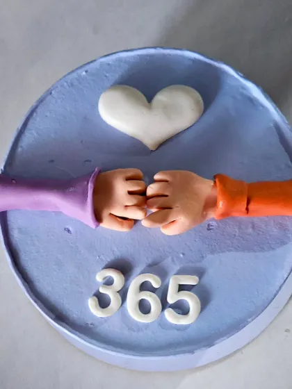 A simple and heartfelt cake topper celebrating "365 days" together. This piece features two hands coming together to form a heart, a perfect symbol for a first anniversary.