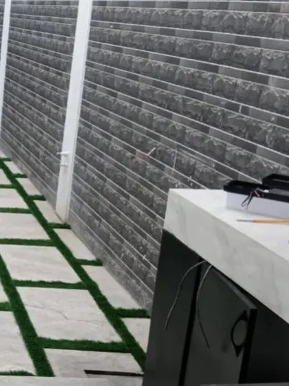 An outdoor utility area with a stone-and-grass path. The artificial grass is durable and easy to clean, making it practical even for functional spaces.
