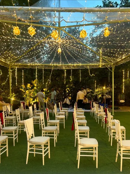An evening ceremony setup with a clear-top tent. This allows guests to sit under the stars and fairy lights, creating a magical ambiance for a wedding or reception.