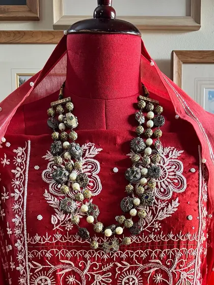 A close-up of the neckline, styled with a statement necklace to show its festive potential.