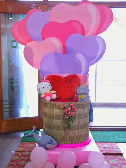 A cute prop featuring a basket of heart-shaped balloons and stuffed animals, perfect for a Valentine's or love-themed birthday.
