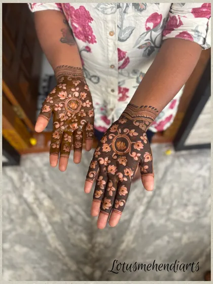 The back of the hands for the lotus-themed guest mehendi, with a central lotus mandala and scattered floral motifs.