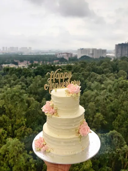This mini three-tiered anniversary cake proves that elegance isn't about size. Finished with a rustic buttercream texture and adorned with simple pink roses, it's a romantic and charming piece.