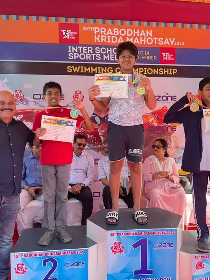 Celebrating a new record holder. Bryce stands proudly on the first-place podium at the 45th Prabodhan Krida Mahotsav after winning gold and setting a new meet record in the butterfly event. Our training focuses on developing the technique and power needed for such record-breaking swims.